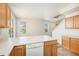 Bright and airy kitchen featuring wood cabinetry, breakfast bar, and ample counter space for meal preparation at 20108 Randolph Pl, Denver, CO 80249
