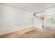 Spacious living room featuring neutral carpeting, crown molding, and staircase access to the upper level at 20108 Randolph Pl, Denver, CO 80249