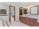 Well-lit bathroom with double vanity sinks, a decorative mirror, and access to the bedroom at 11545 Quivas Way, Westminster, CO 80234