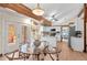 Bright kitchen with white cabinets, wood beams, and a breakfast nook with deck access at 11545 Quivas Way, Westminster, CO 80234