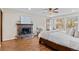 Main bedroom featuring a brick fireplace, hardwood floors, and access to a private balcony at 11545 Quivas Way, Westminster, CO 80234