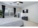 Well-lit bedroom with neutral carpet, a ceiling fan, and view of the sliding glass door at 3993 S Dillon Way # 104, Aurora, CO 80014