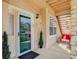 Inviting front porch with seating area, exterior door, and security system at 3993 S Dillon Way # 104, Aurora, CO 80014