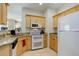 Kitchen featuring granite countertops, light wood cabinets, and a modern white appliance package at 3993 S Dillon Way # 104, Aurora, CO 80014
