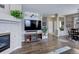 Spacious living room with hardwood floors, fireplace, TV, and view of dining area at 3993 S Dillon Way # 104, Aurora, CO 80014