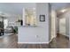 Open-concept living room with dark wood floors, leading to a bright kitchen and front entry at 3993 S Dillon Way # 104, Aurora, CO 80014