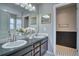 Bathroom with a double sink vanity, dark wood cabinets, and white flowers for decor at 9445 E 106Th Pl, Commerce City, CO 80640