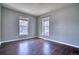 Bedroom with dark floors and two windows at 9445 E 106Th Pl, Commerce City, CO 80640