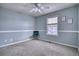 This carpeted bedroom has natural light, a stylish blue chair, and fresh neutral paint at 9445 E 106Th Pl, Commerce City, CO 80640