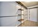 An industrial style closet with metal bar and wood shelf storage and neutral carpeted floor at 9445 E 106Th Pl, Commerce City, CO 80640