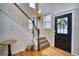 Elegant foyer showcasing a staircase with wooden accents, a stylish front door, and gleaming hardwood floors at 9445 E 106Th Pl, Commerce City, CO 80640