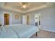 This main bedroom features plush carpet, tray ceilings, and access to a closet and bathroom at 9445 E 106Th Pl, Commerce City, CO 80640