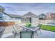 The backyard patio has a table and chairs, with a fire pit centerpiece at 9445 E 106Th Pl, Commerce City, CO 80640