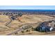 An aerial view showcases the neighborhood and the city skyline in the distance at 17577 W 87Th Ave, Arvada, CO 80007