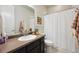 Cozy bathroom featuring a vanity with mirror, toilet, and shower with a white curtain at 17577 W 87Th Ave, Arvada, CO 80007