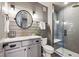 Modern bathroom features a glass walk-in shower, round mirror, and grey shiplap walls at 17577 W 87Th Ave, Arvada, CO 80007