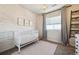 Bright Bedroom with white wood accent wall, white crib and a soft pink rug at 17577 W 87Th Ave, Arvada, CO 80007