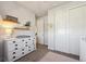 Bedroom with a white dresser and changing table, decor shelves, and double-door closet at 17577 W 87Th Ave, Arvada, CO 80007