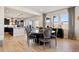 Dining area with a round table, upholstered chairs, hardwood floors, and a view into the modern kitchen at 17577 W 87Th Ave, Arvada, CO 80007