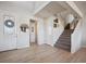 Bright entryway with hardwood floors, a staircase leading to the second floor, and a decorative wreath on the front door at 17577 W 87Th Ave, Arvada, CO 80007