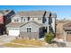 Beautiful two-story home featuring gray siding, stone accents, a well-manicured lawn and an attached two car garage at 17577 W 87Th Ave, Arvada, CO 80007