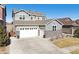 A stylish home featuring stone accents, gray siding, an attached two-car garage, and a well-maintained front lawn at 17577 W 87Th Ave, Arvada, CO 80007