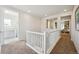 Upstairs hallway with open railing, neutral carpet, and view to rooms at 17577 W 87Th Ave, Arvada, CO 80007