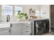 Well-organized laundry room with modern gray cabinets, a sink, countertop, and washer/dryer at 17577 W 87Th Ave, Arvada, CO 80007