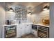 Cozy wet bar features light gray cabinets, a sink, and an assortment of drink mugs at 17577 W 87Th Ave, Arvada, CO 80007