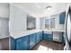 Inviting kitchen featuring blue cabinetry, stainless appliances, and mosaic backsplash at 4025 S Fundy Way, Aurora, CO 80013