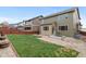 Backyard view of a two-story house with a well-manicured lawn, patio area, and privacy fence, creating an outdoor retreat at 16685 E 101St Ave, Commerce City, CO 80022