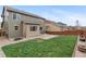 Backyard view of a house featuring a well-maintained lawn, patio area, and wooden fence, creating an outdoor living space at 16685 E 101St Ave, Commerce City, CO 80022