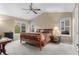 Spacious bedroom featuring a ceiling fan, and large windows that provide ample natural light and views of the neighborhood at 16685 E 101St Ave, Commerce City, CO 80022