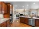 Open kitchen with stainless steel appliances and granite countertops that leads to a living area at 16685 E 101St Ave, Commerce City, CO 80022