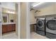 Convenient laundry room features modern appliances, countertop space, and shelving for efficient and organized laundry care at 16685 E 101St Ave, Commerce City, CO 80022