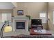 Cozy living room featuring a classic fireplace, mantel, and large windows providing ample natural light at 16685 E 101St Ave, Commerce City, CO 80022
