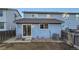 Exterior view of a light blue two-story home, complete with sliding glass doors and compact backyard at 11039 Columbine St, Northglenn, CO 80233