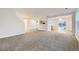 Open-concept living room featuring neutral carpet, bright white walls, and ample natural light at 11039 Columbine St, Northglenn, CO 80233