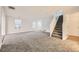 Spacious living room featuring carpet flooring, bright white walls, and a staircase at 11039 Columbine St, Northglenn, CO 80233
