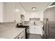 Updated kitchen features stainless steel appliances, white cabinets, stone countertops and gray tile floors at 1000 E 8Th Ave # 4, Denver, CO 80218