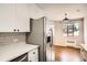Updated kitchen features white cabinets, subway tile backsplash, stainless steel refrigerator, and stone countertops at 1000 E 8Th Ave # 4, Denver, CO 80218