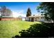Expansive backyard with a large, green lawn and a storage shed, ideal for outdoor activities and storage at 1183 S Umatilla St, Denver, CO 80223