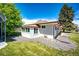 Charming home exterior featuring landscaped yard and bright, sunny day at 1183 S Umatilla St, Denver, CO 80223
