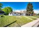 Landscaped front yard featuring a mature shade tree on a sunny day at 1183 S Umatilla St, Denver, CO 80223