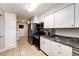 Bright kitchen featuring stainless steel appliances, granite countertops, and white cabinets at 1183 S Umatilla St, Denver, CO 80223