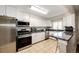 Modern kitchen featuring granite countertops, stainless steel appliances, and tiled floors at 1183 S Umatilla St, Denver, CO 80223