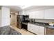 Bright kitchen featuring stainless steel appliances, granite countertops, and white cabinets at 1183 S Umatilla St, Denver, CO 80223