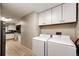 Well-lit laundry room featuring modern appliances and ample storage, perfect for efficient home management at 1183 S Umatilla St, Denver, CO 80223
