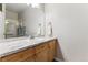 Bright bathroom featuring wood cabinets, marble countertops, and a shower stall at 7375 S Alkire St # 102, Littleton, CO 80127