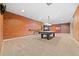 Carpeted basement area featuring a pool table, wall bar, and exposed brick at 6420 Agave Ave, Castle Rock, CO 80108
